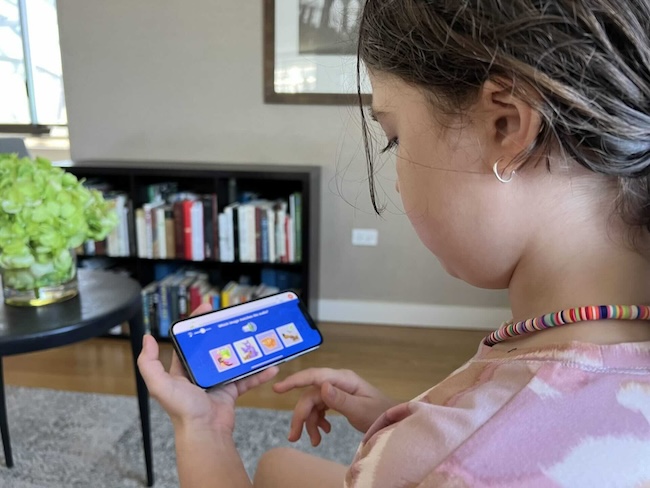 Girl studies the Dinolingo phone app